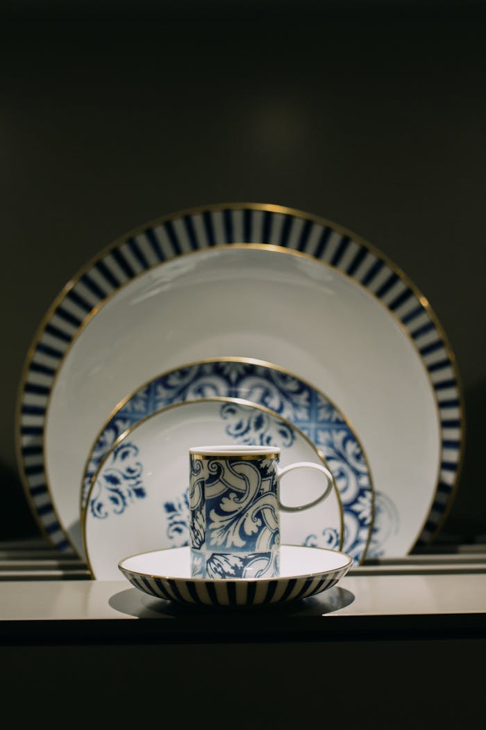 about-us-02 Close-up of a sophisticated blue and white ceramic dinnerware set with intricate patterns.